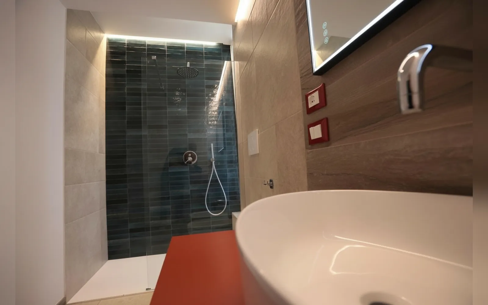 Il bagno privato con la doccia a parete blu e il lavabo in ceramica
